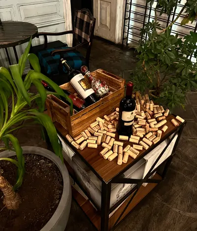 A wooden wine crate full of corks and bottles among the plants