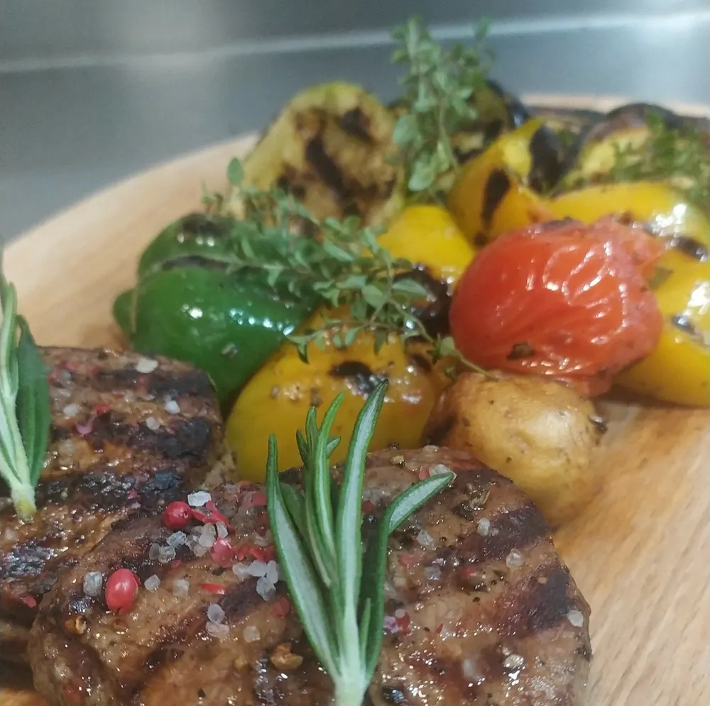 A grilled steak with rosemary and roasted vegetables